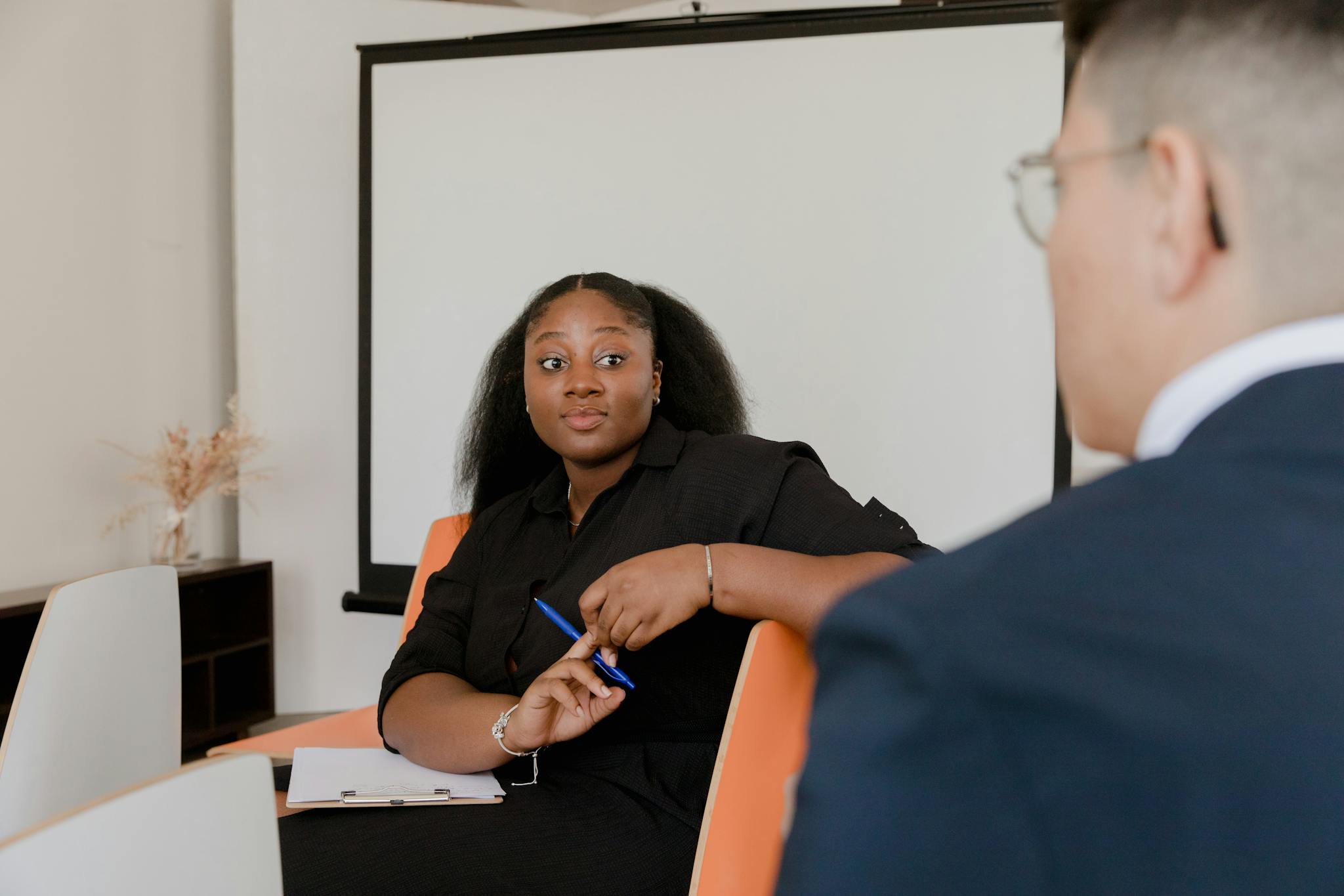 Two colleagues engage in a corporate discussion in an office setting.